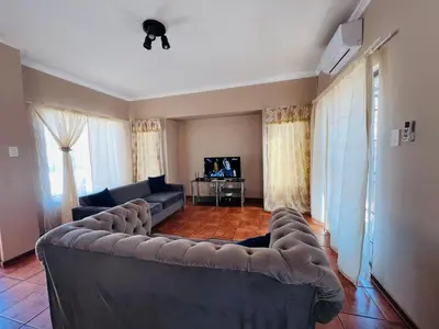 a living room with a couch and a television at Royal Apartments in Burgersfort