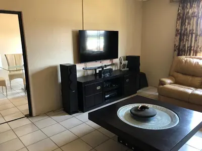 a living room with a television and a table at Horizon small holding in Polokwane