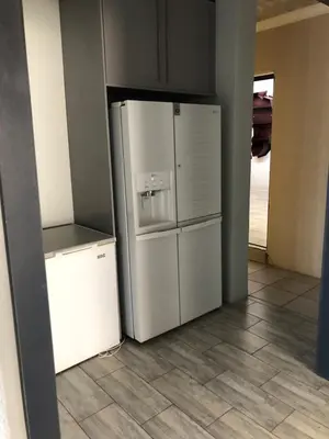 a kitchen with a white refrigerator and a tile floor at Horizon small holding in Polokwane