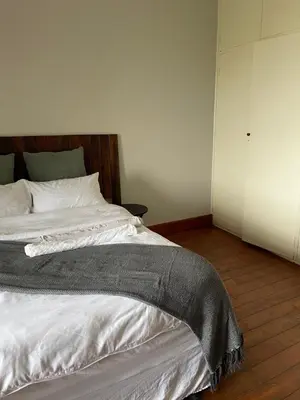 a bedroom with a large bed with white sheets at Lani Accommodation in Pretoria
