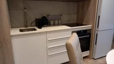 a small kitchen with a sink and a refrigerator at Luxury 7th Floor Menlyn Maine Residences in Pretoria