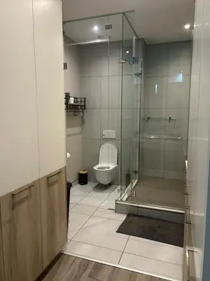 a bathroom with a toilet and a glass shower at Luxury 7th Floor Menlyn Maine Residences in Pretoria