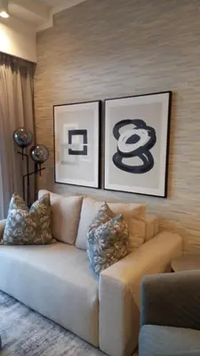 a living room with a couch and two pictures on the wall at Luxury 7th Floor Menlyn Maine Residences in Pretoria