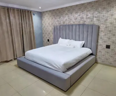 a bedroom with a large bed with a large bed frame at Pereng Lodge in Ga-Moloi