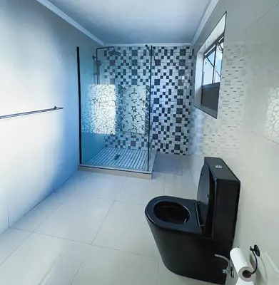 a bathroom with a shower and a toilet in it at Pereng Lodge in Ga-Moloi