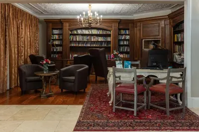 a living room with a table and chairs and a library at The 506 Hotel in Midrand