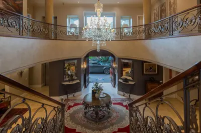 a staircase with a chandelier and a table in a house at The 506 Hotel in Midrand