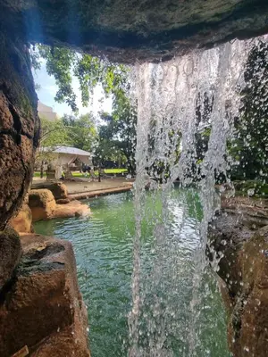 a waterfall over a pond in a park at The 506 Hotel in Midrand