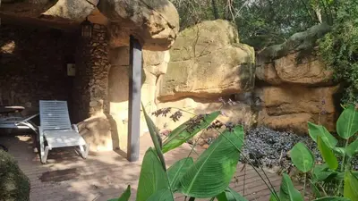 a chair sitting on a patio next to a rock wall at The 506 Hotel in Midrand