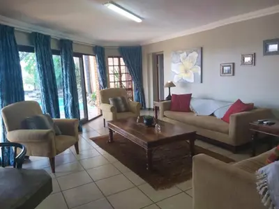 a living room with couches and a coffee table at Sunset Cottage - Own Water - Own Electricity in Pretoria