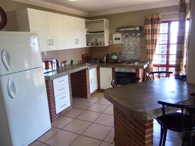 a kitchen with a white refrigerator and a table at Sunset Cottage - Own Water - Own Electricity in Pretoria