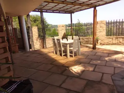 a patio with a table and chairs on a patio at Sunset Cottage - Own Water - Own Electricity in Pretoria