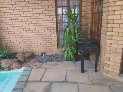 a black bench sitting in front of a building at Sunset Cottage - Own Water - Own Electricity in Pretoria