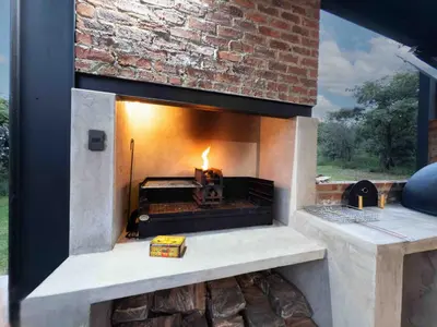 a stone fireplace with a fire in it at vanDijksRus Farm in The Waterberg Biosphere