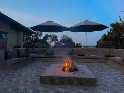 a fire pit with two umbrellas on a patio at vanDijksRus Farm in The Waterberg Biosphere