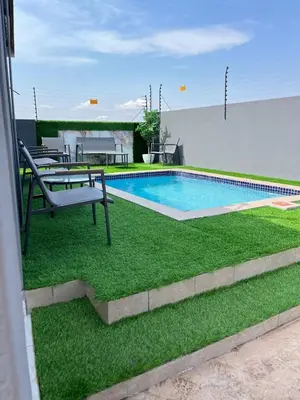 a small swimming pool with a bench and grass at Marikana guest house