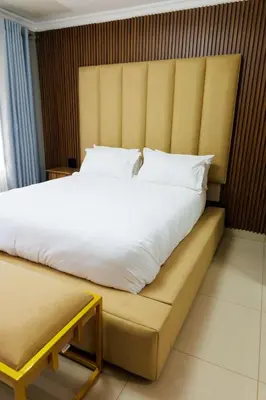 a bedroom with a large white bed with a bench at Marikana guest house