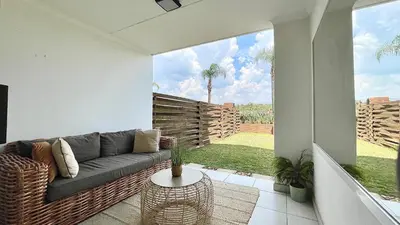 a living room with a couch and a large window at The Blyde - Lagoon Facing 3 Bedroom apartment in Pretoria