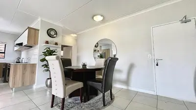 a kitchen and dining room with a table and chairs at The Blyde - Lagoon Facing 3 Bedroom apartment in Pretoria