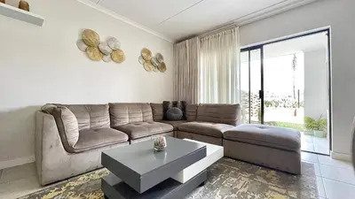 a living room with a couch and a table at The Blyde - Lagoon Facing 3 Bedroom apartment in Pretoria