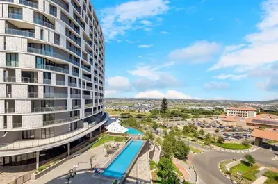 an aerial view of a tall building with a pool at Mphoentle Residence ellipse waterfall in Midrand