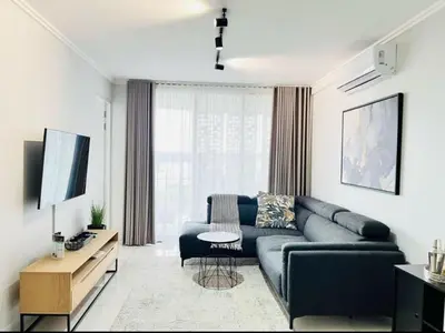a living room with a couch and a television at Mphoentle Residence ellipse waterfall in Midrand