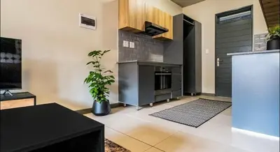 a living room with a kitchen with a refrigerator at Elegant escape in Midrand in Midrand