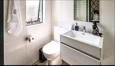 a white bathroom with a toilet and a sink at Elegant escape in Midrand in Midrand
