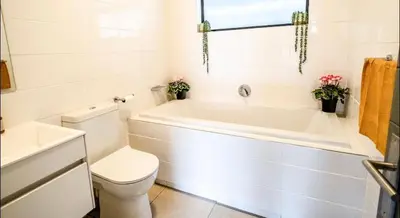 a bathroom with a tub and a toilet and a sink at Elegant escape in Midrand in Midrand