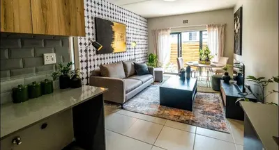 a living room with a couch and a table at Elegant escape in Midrand in Midrand