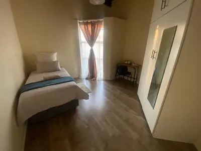 a bedroom with a bed and a window at Mbobo Legacy Residence in Pretoria