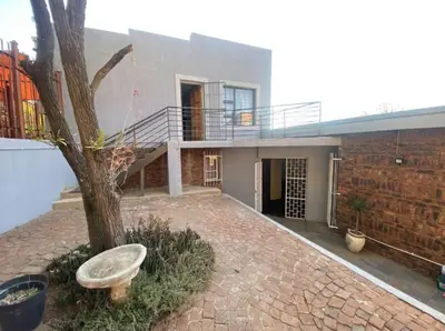 a house with a tree in front of a building at Mbobo Legacy Residence in Pretoria