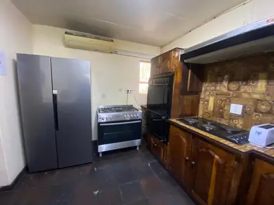 a kitchen with a refrigerator and a stove at Mbobo Legacy Residence in Pretoria