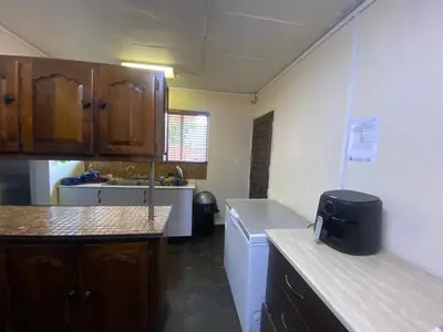 a kitchen with wooden cabinets and a sink and a counter at Mbobo Legacy Residence in Pretoria