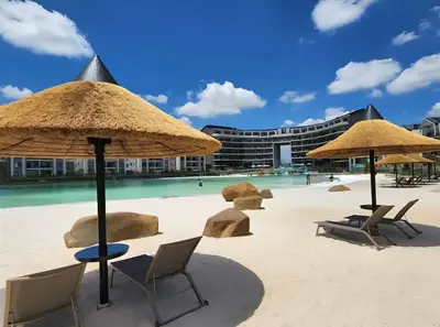 a beach with chairs and umbrellas and a swimming pool at Crystal ace lagoon in Midrand