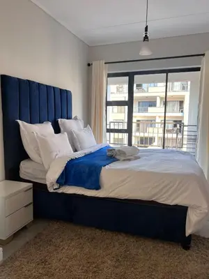 a large bed with a blue headboard in a bedroom at Crystal ace lagoon in Midrand