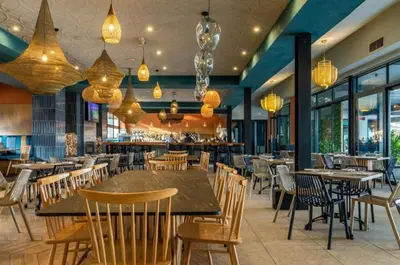 a restaurant with wooden tables and chairs and chandeliers at The Blyde Crystal Lagoon Pretoria 3Bed in Pretoria