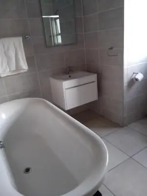 a bathroom with a white tub and a sink at The Blyde Crystal Lagoon Pretoria 3Bed in Pretoria
