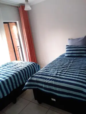 a bedroom with two beds and a window at The Blyde Crystal Lagoon Pretoria 3Bed in Pretoria