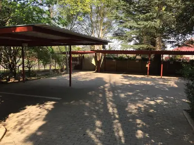 a pavilion in a park with trees and a fence at JC Studios Ermelo in Ermelo