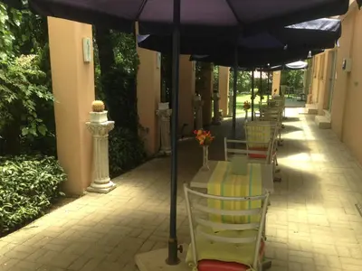a row of tables and chairs under an umbrella at JC Studios Ermelo in Ermelo