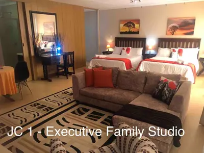 a living room with two beds and a couch at JC Studios Ermelo in Ermelo
