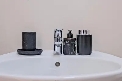 a counter with a bottle of perfume and other items at Nat's Villa in Midrand