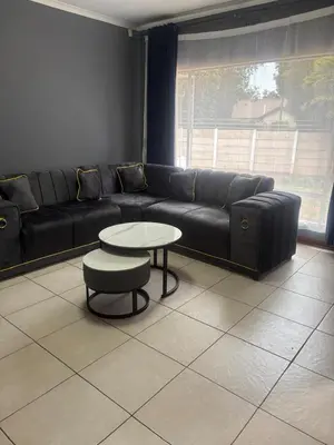 a living room with a black couch and a table at Ruros Guest House in Kempton Park