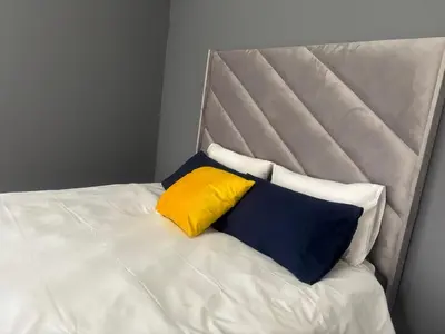 a bed with three pillows on top of it at Ruros Guest House in Kempton Park