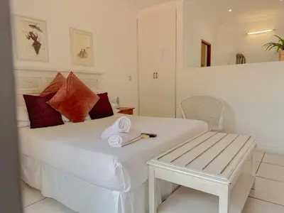 a bedroom with a white bed with towels on it at Amoris Guesthouse - Waterkloof ridge in Pretoria
