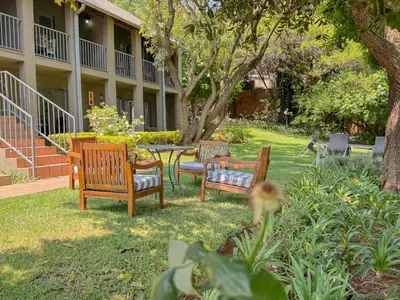 three chairs and a table in a yard at Amoris Guesthouse - Waterkloof ridge in Pretoria