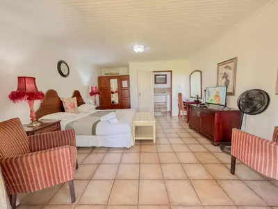 a bedroom with a bed and a table and chairs at Amoris Guesthouse - Waterkloof ridge in Pretoria