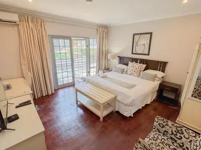 a bedroom with a large white bed in a room at Amoris Guesthouse - Waterkloof ridge in Pretoria