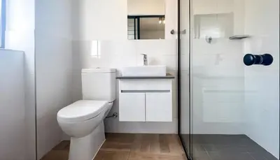 a white bathroom with a toilet and a shower at Elegant stay in Midrand